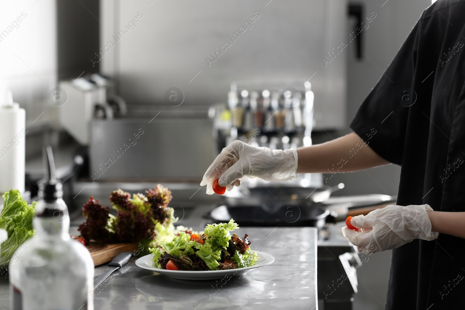 Photo of Female chef cooking tasty food in restaurant kitchen, closeup