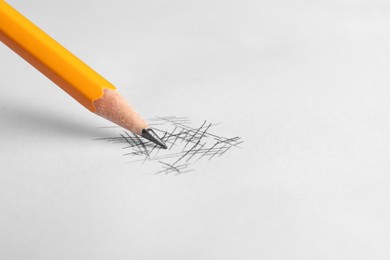 Photo of One sharp graphite pencil and scribbles on white background, closeup. Space for text