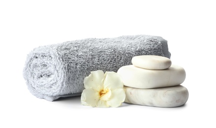 Photo of Spa stones, fresh flower and towel on white background