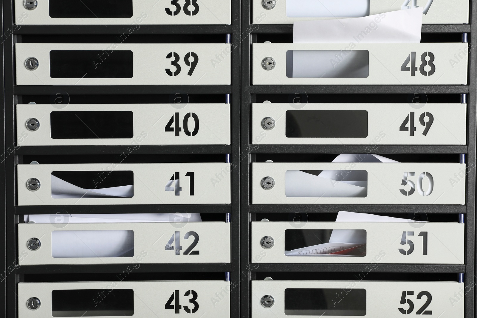 Photo of Metal mailboxes with keyholes, numbers and receipts as background