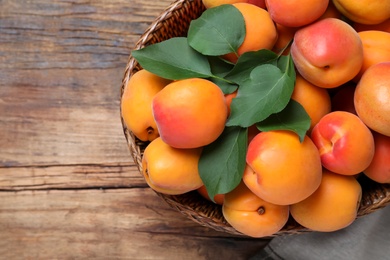 Photo of Delicious fresh ripe apricots on wooden table, top view