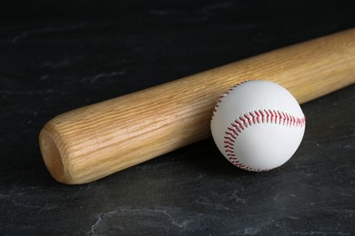 Photo of Baseball bat and ball on black background. Sports equipment