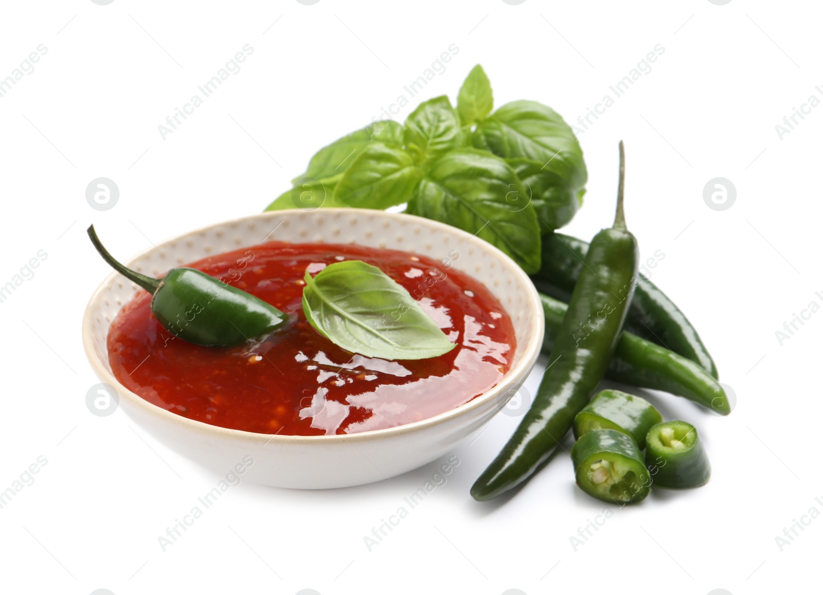 Photo of Spicy chili sauce and ingredients on white background