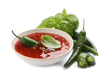 Photo of Spicy chili sauce and ingredients on white background