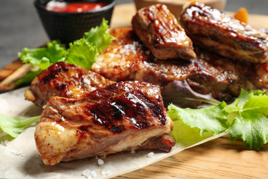 Delicious grilled ribs on board, closeup view