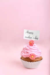 Topper with words HAPPY MOTHER'S DAY in cupcake on color background