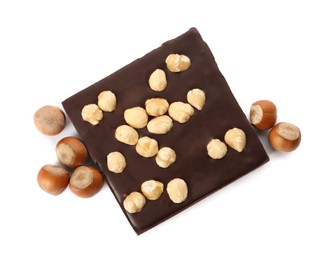 Photo of Delicious chocolate bar and hazelnuts on white background, top view