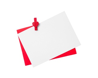 Photo of Blank card, envelope and red decorative clothespin on white background, top view. Valentine's Day concept