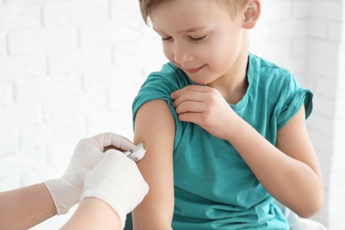 Doctor vaccinating little boy in hospital