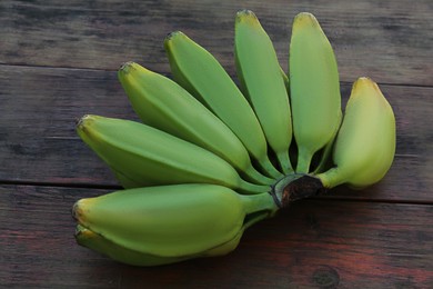 Photo of Bunch of delicious bananas on wooden table, closeup