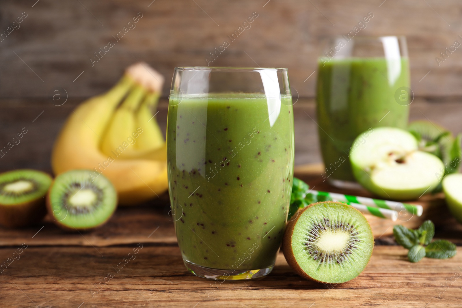 Photo of Delicious kiwi smoothie and fresh fruits on wooden table