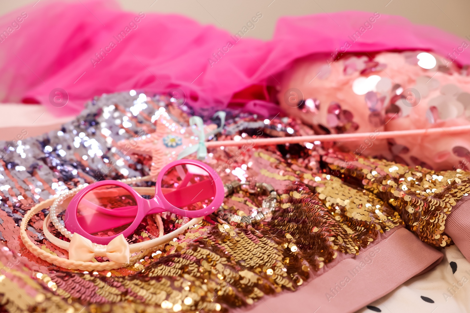 Photo of Stylish carnival costume with sequins, sunglasses, wand and headbands, closeup