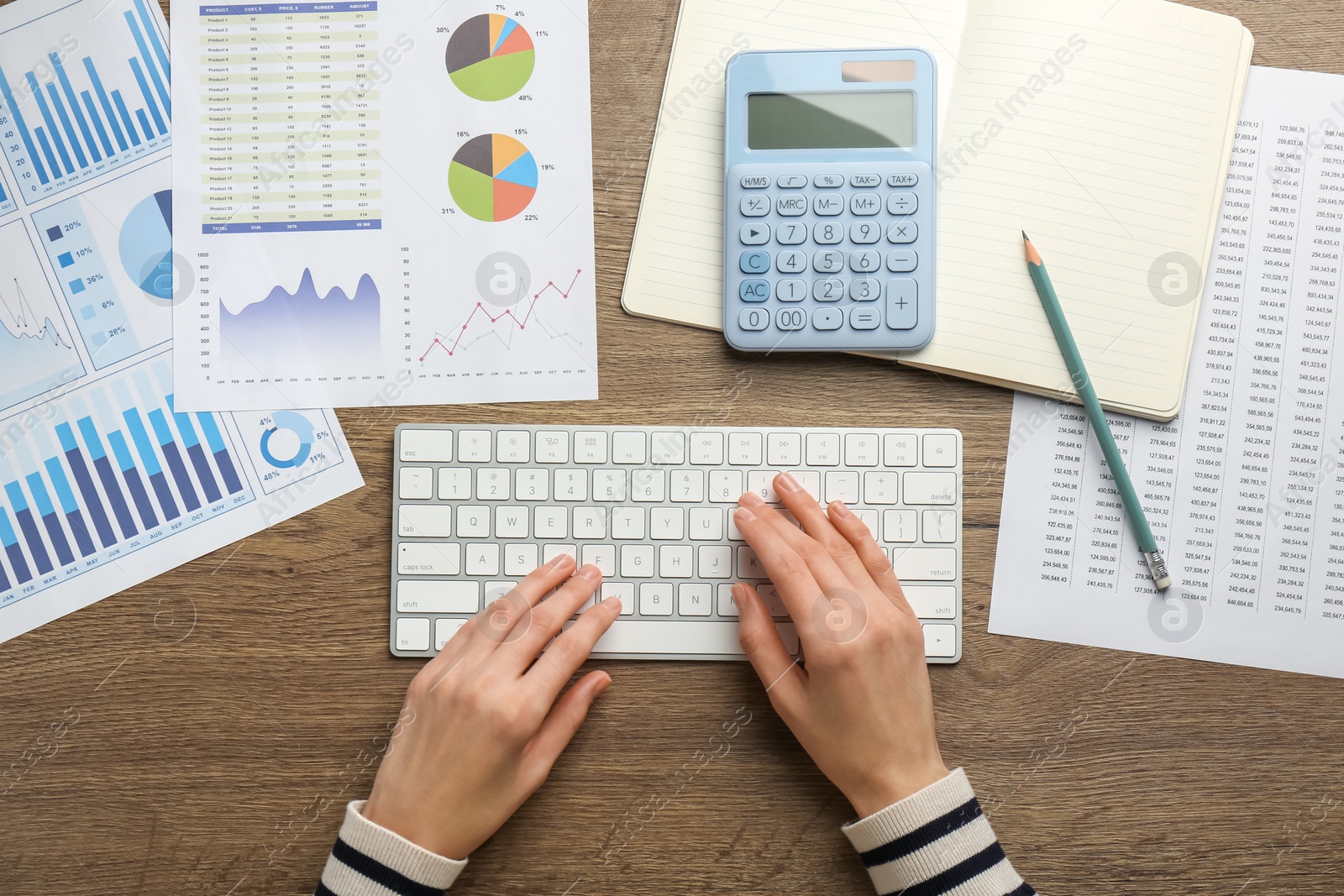 Photo of Accountant working on computer at wooden table, top view