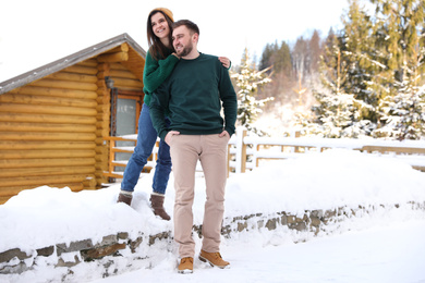 Photo of Lovely couple walking together on snowy day. Winter vacation