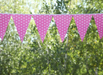 Photo of Pink bunting flags in park. Party decor