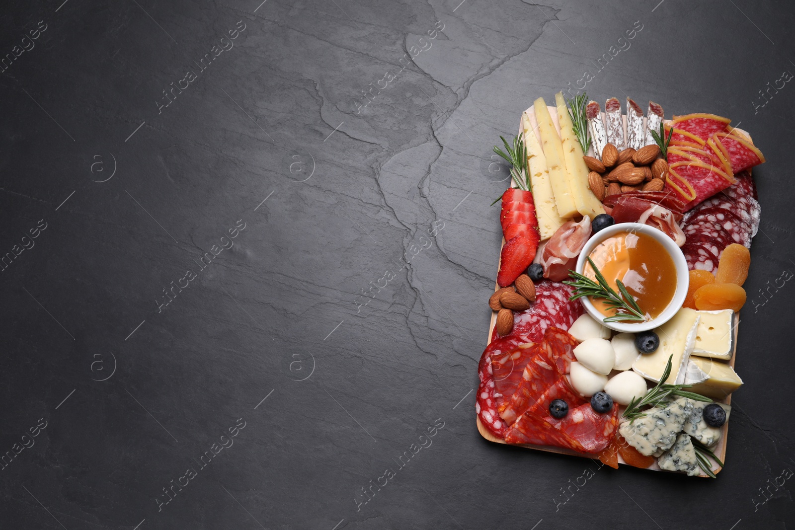 Photo of Different delicious snacks on black table, top view. Space for text