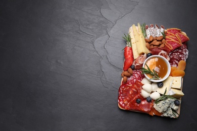 Different delicious snacks on black table, top view. Space for text