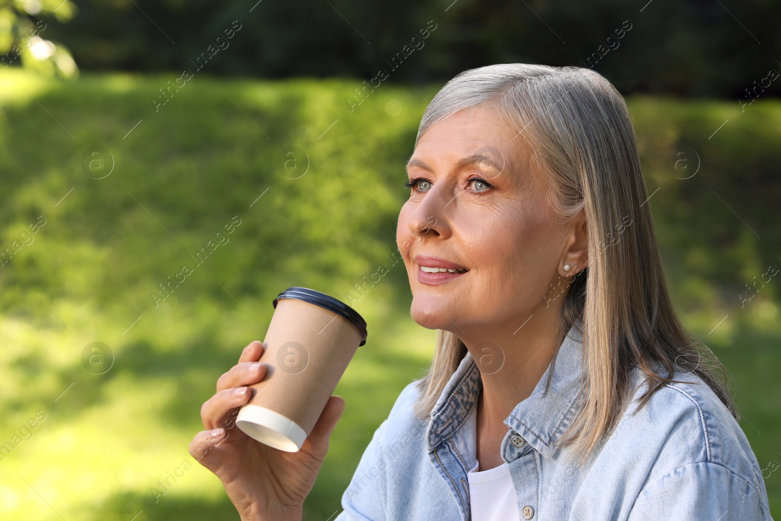 Photo of Portrait of beautiful senior woman with paper cup of coffee outdoors