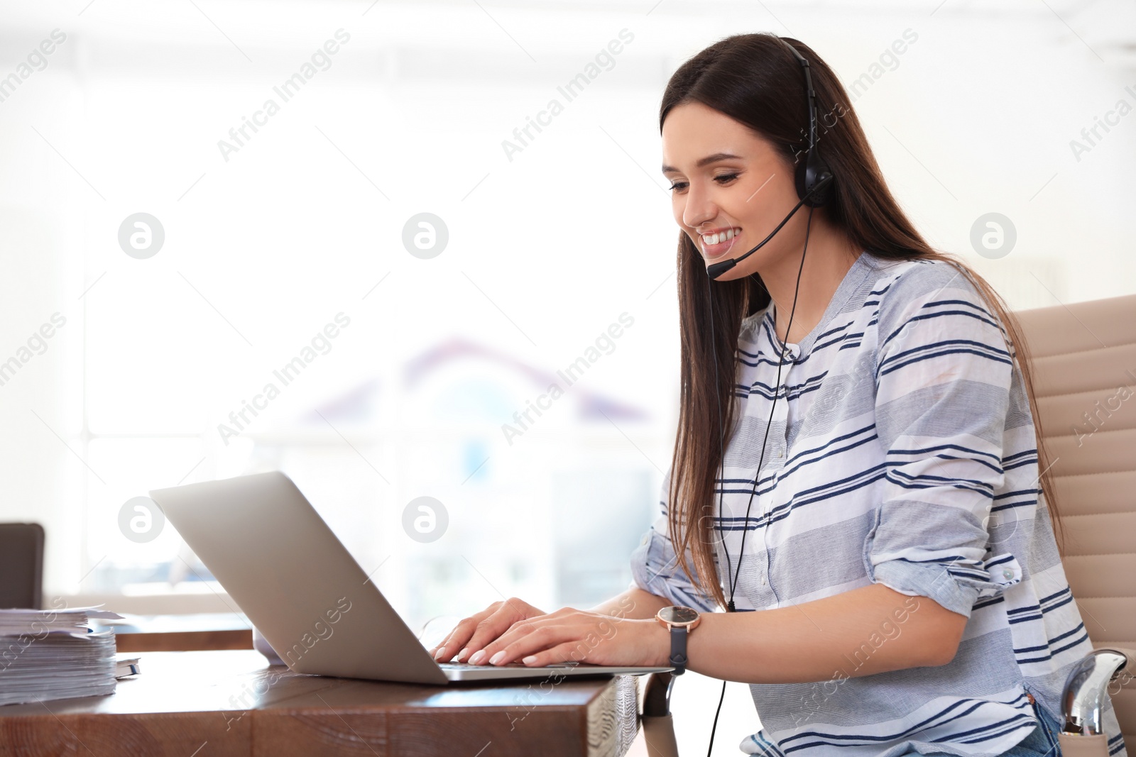 Photo of Young woman using video chat on laptop in home office