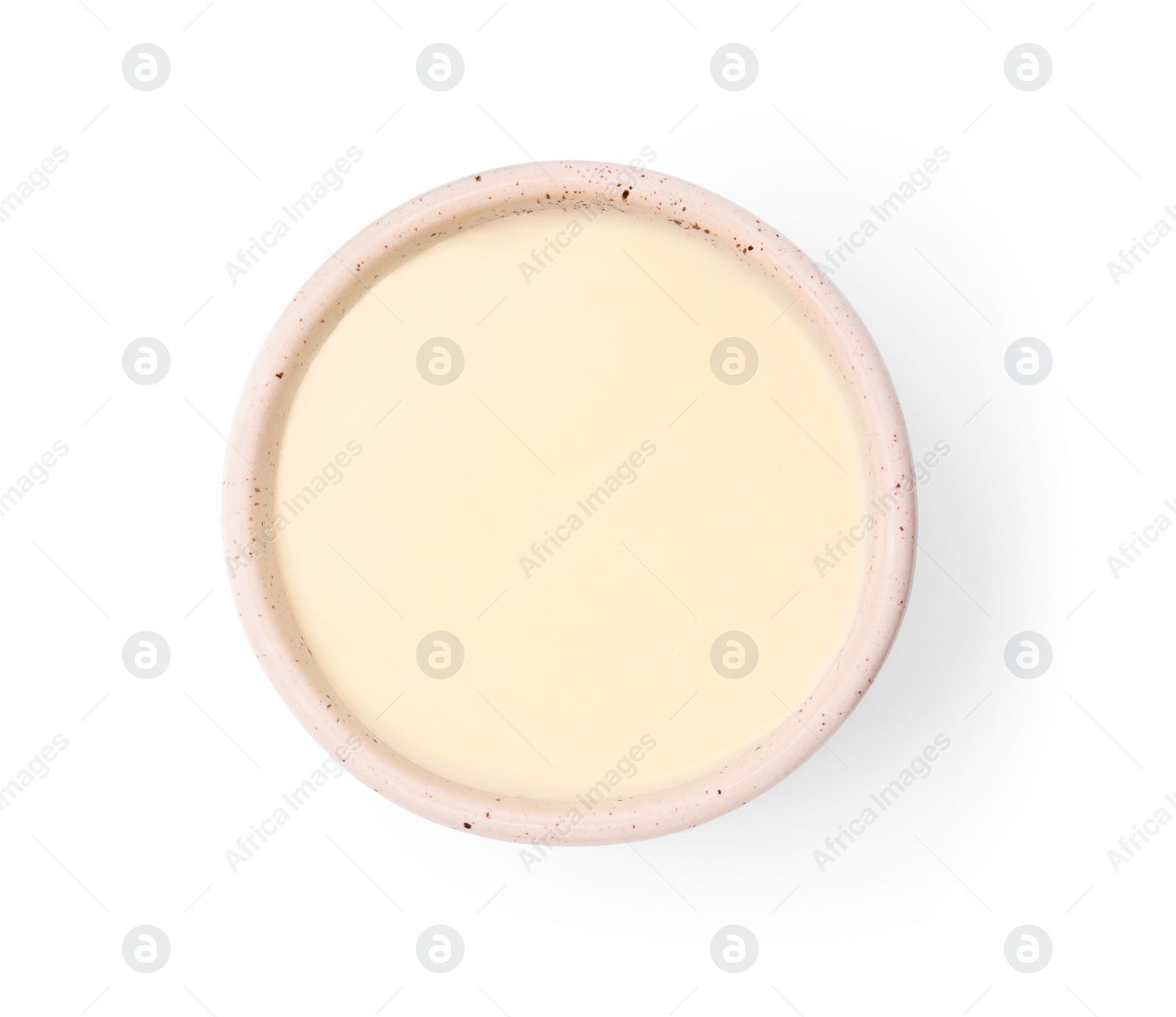 Photo of Bowl with condensed milk isolated on white, top view