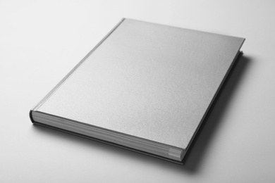 Closed grey book with hard cover on white background