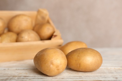 Photo of Fresh ripe organic potatoes on wooden table