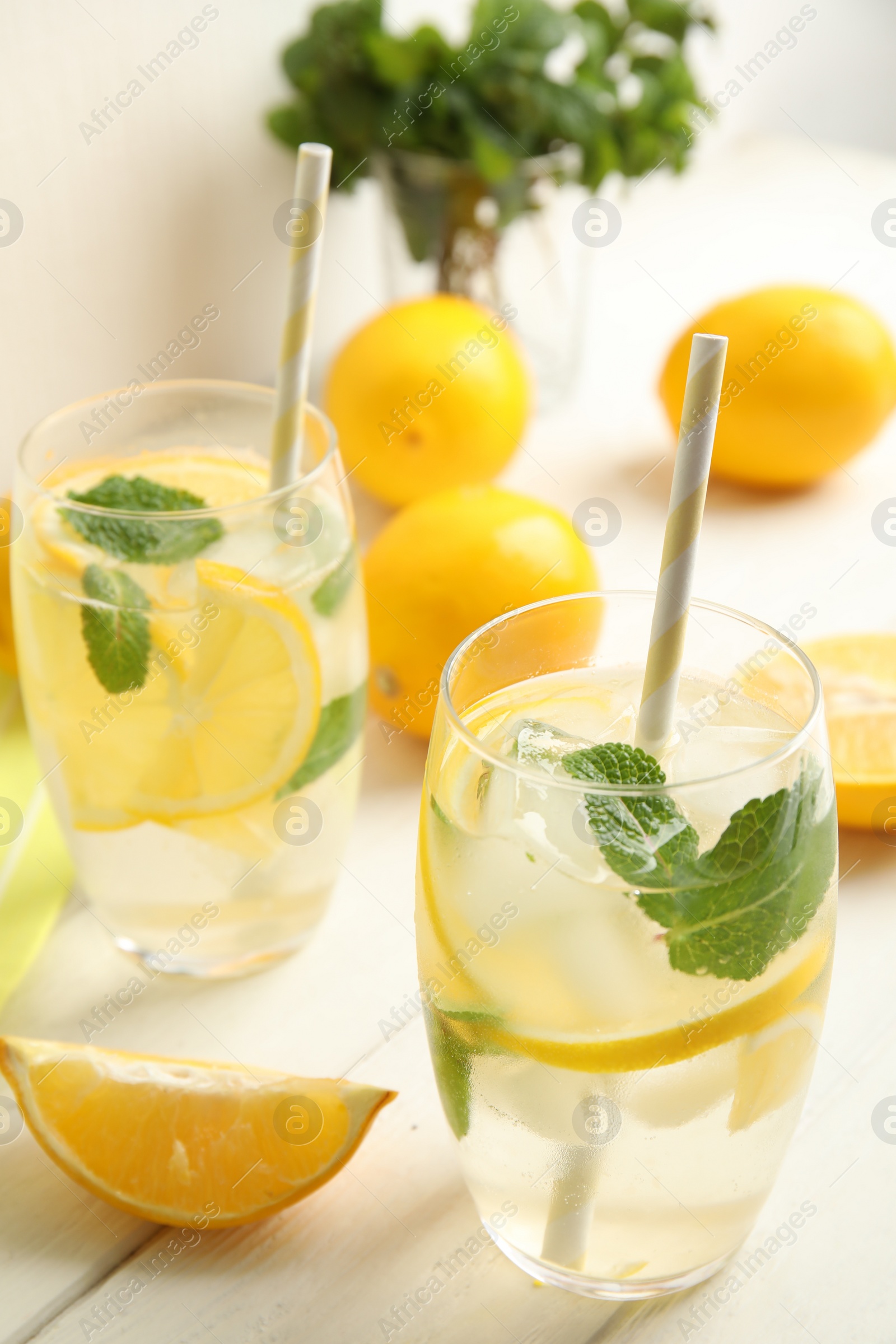 Photo of Cool freshly made lemonade and fruits on white wooden table