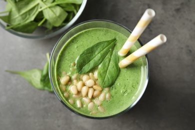 Photo of Flat lay composition with fresh green healthy spinach smoothie on grey table