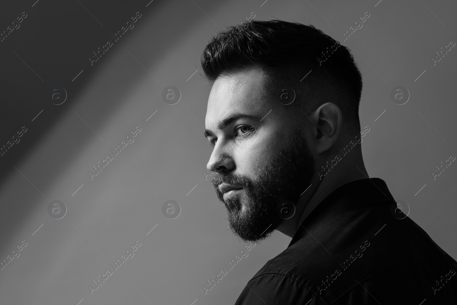 Photo of Portrait of handsome bearded man on grey background, space for text. Black and white effect