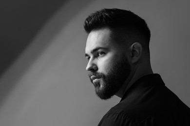 Photo of Portrait of handsome bearded man on grey background, space for text. Black and white effect