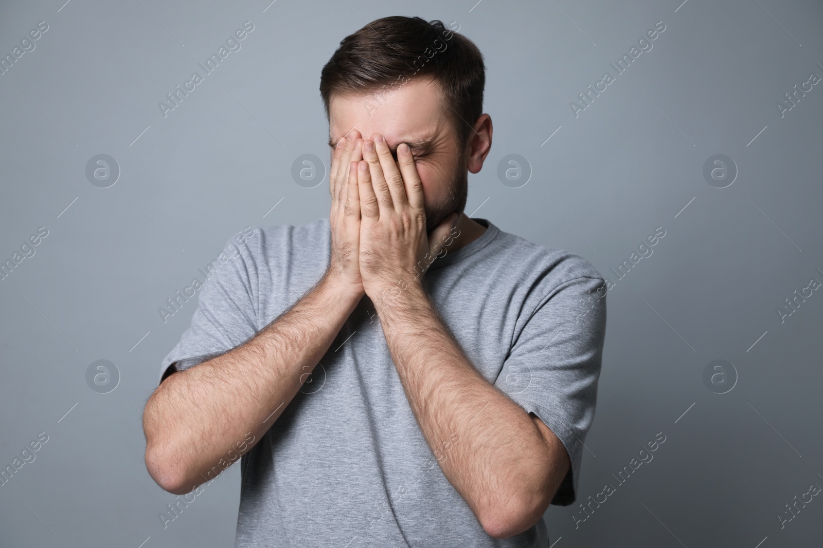 Photo of Young man feeling fear on grey background