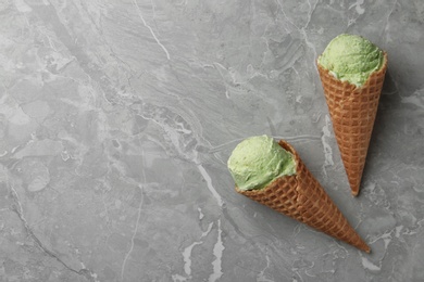 Photo of Delicious pistachio ice cream on grey marble table, flat lay. Space for text