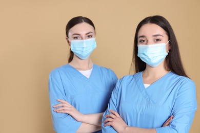 Photo of Nurses wearing protective masks on light brown background