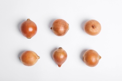 Photo of Beautiful composition with ripe onions on white background