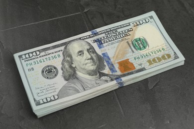 Photo of Money exchange. Dollar banknotes on dark gray textured background, closeup
