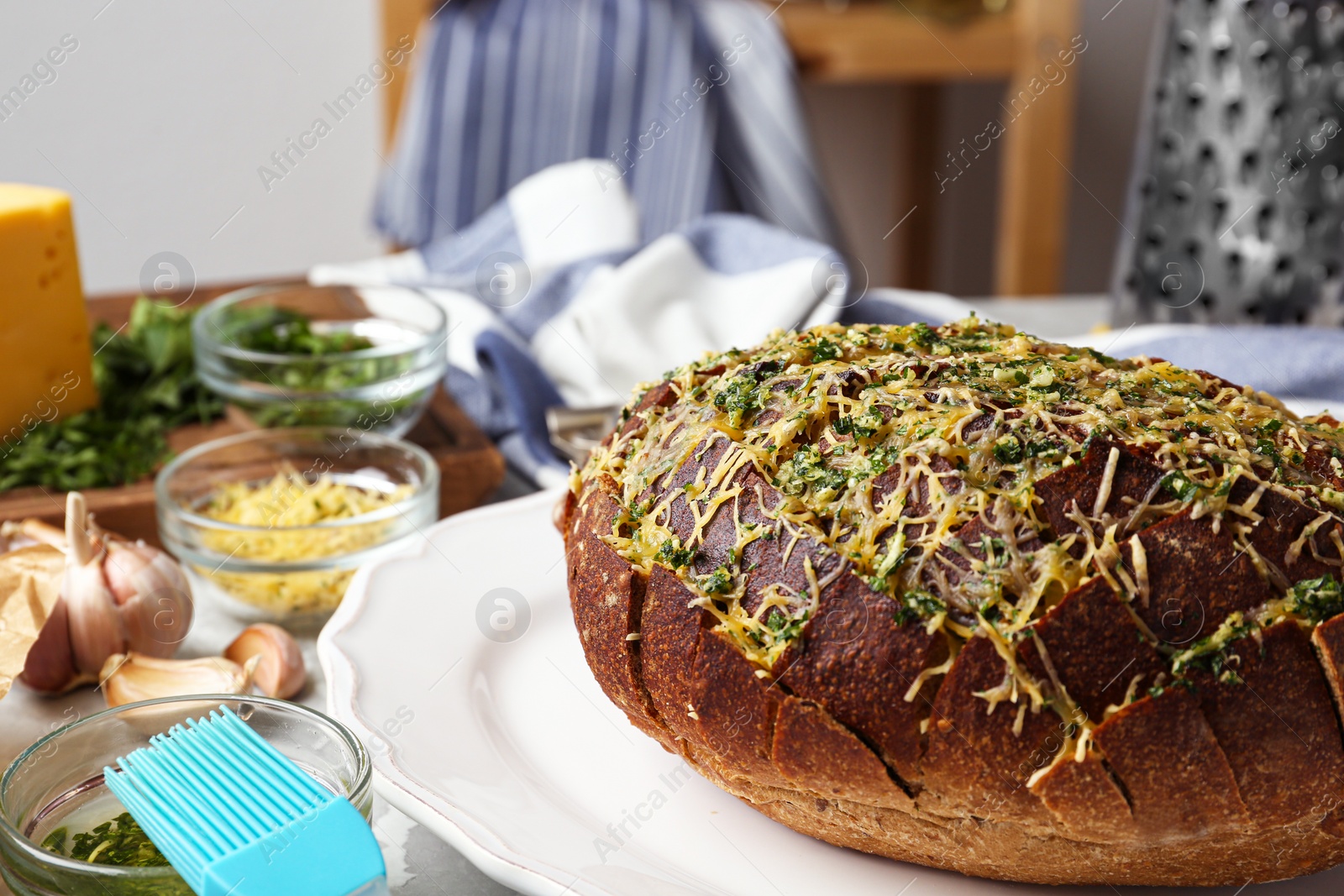 Photo of Tasty homemade garlic bread  with cheese and herbs on table. Space for text