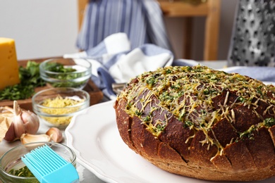 Photo of Tasty homemade garlic bread  with cheese and herbs on table. Space for text