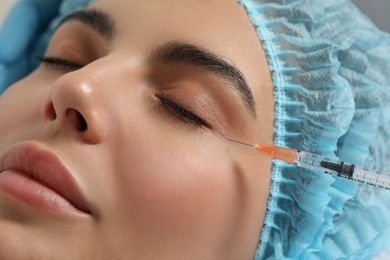 Young woman getting facial injection in clinic, closeup. Cosmetic surgery