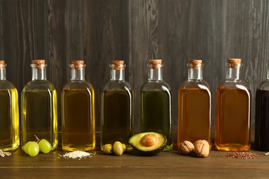 Vegetable fats. Different oils in glass bottles and ingredients on wooden table