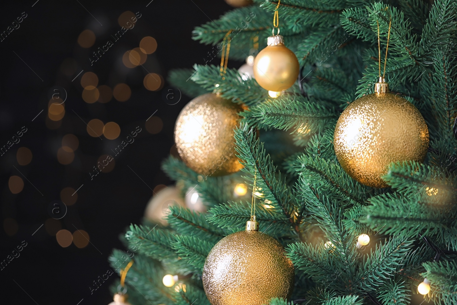 Photo of Beautiful Christmas tree with festive decor against blurred lights on background, closeup