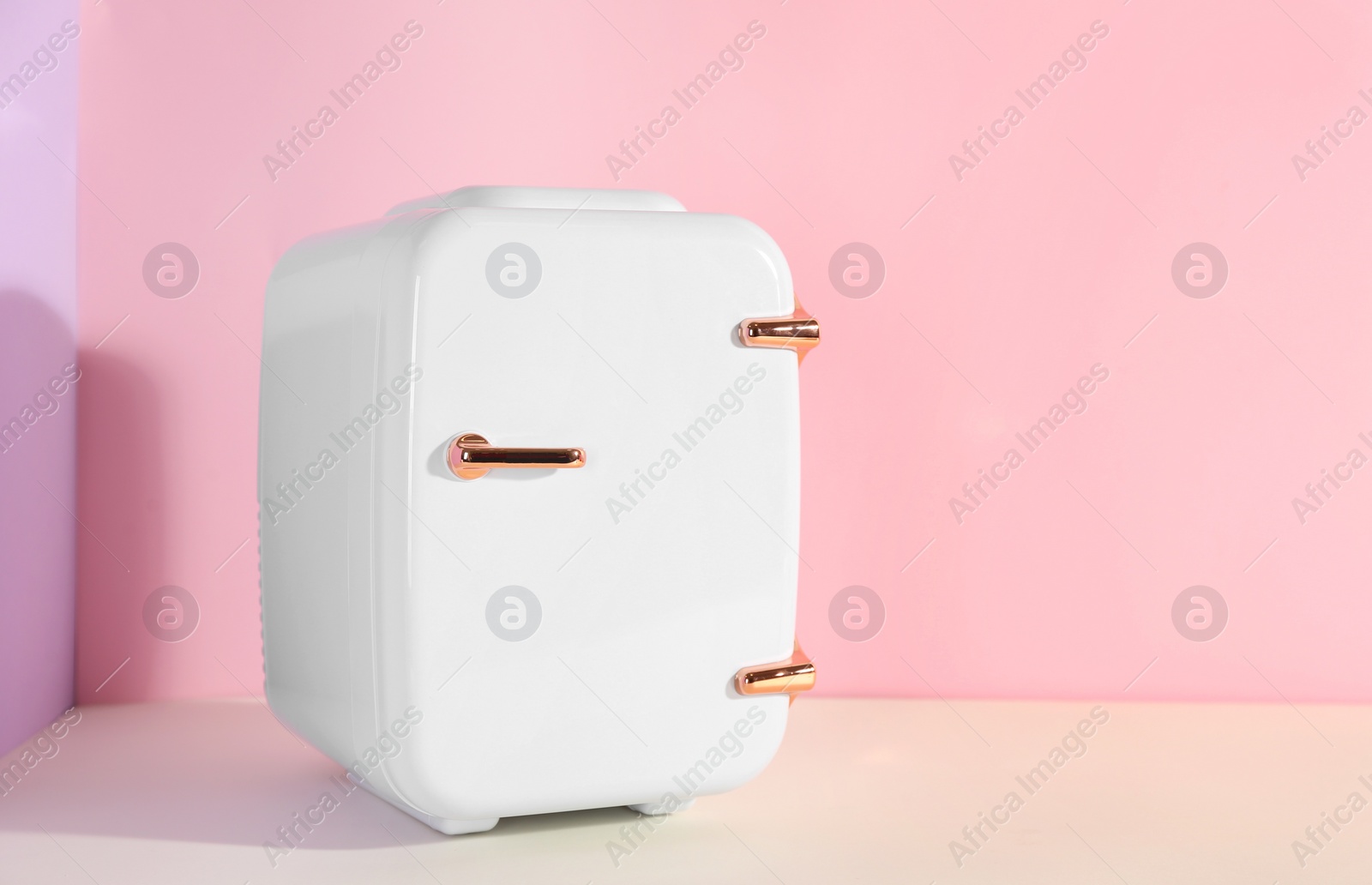 Photo of Cosmetic refrigerator on color background, space for text