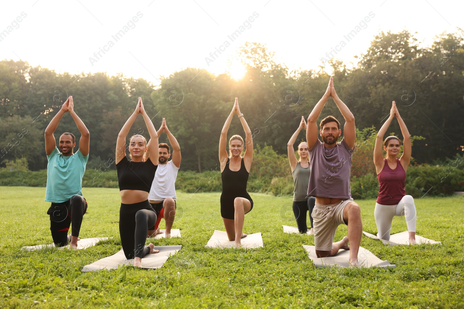 Photo of Group of people practicing yoga on mats outdoors