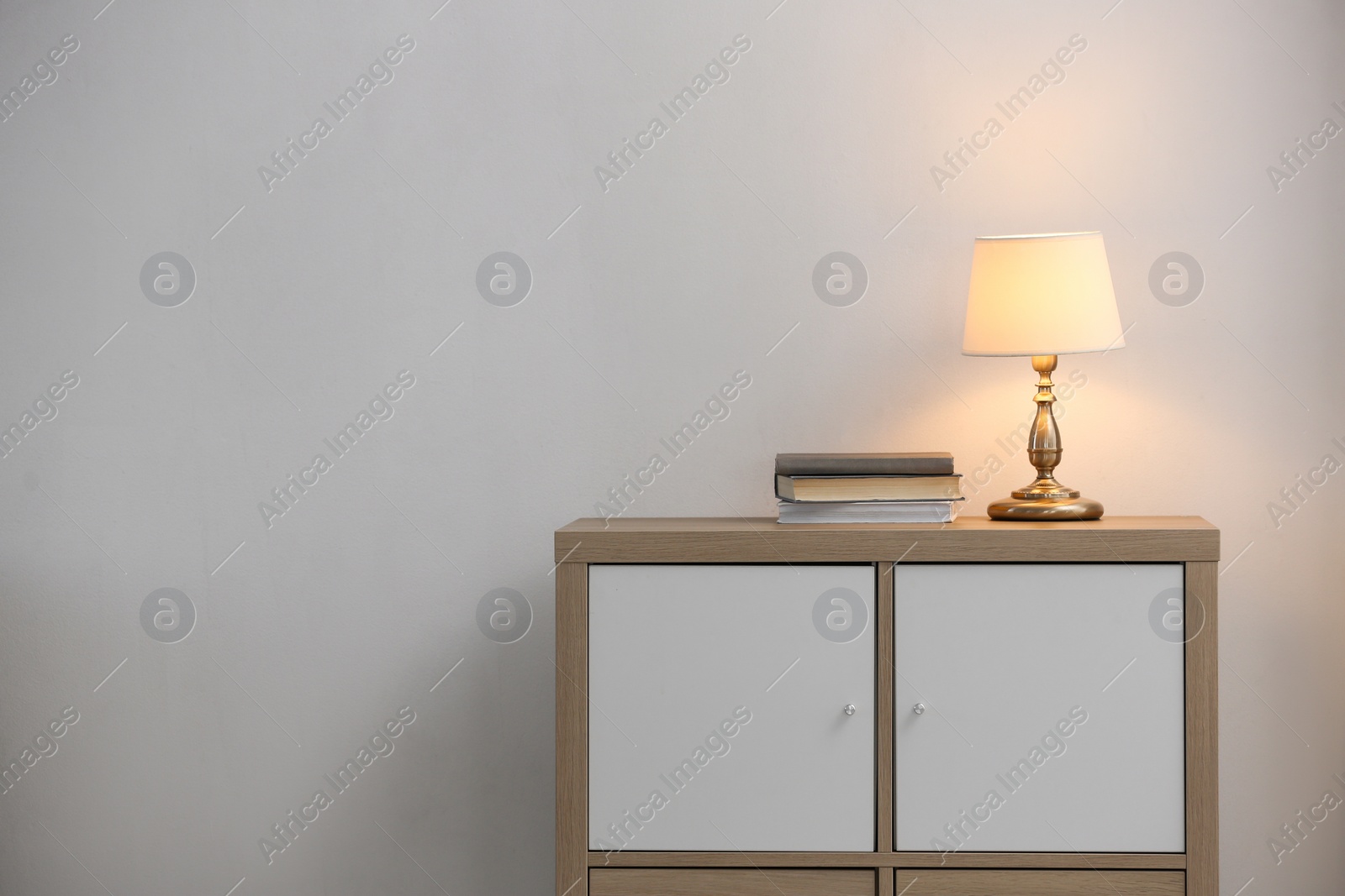 Photo of Stylish cabinet with lamp in living room