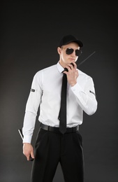 Photo of Male security guard using portable radio transmitter on dark background