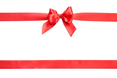 Red ribbons with bow on white background, top view