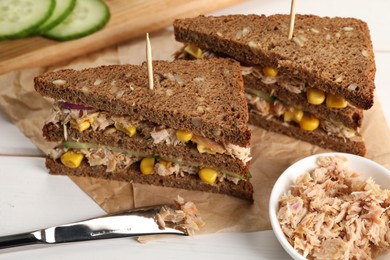 Delicious sandwiches with tuna and vegetables on white table