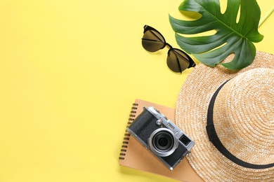 Flat lay composition with stylish hat, camera and sunglasses on color background