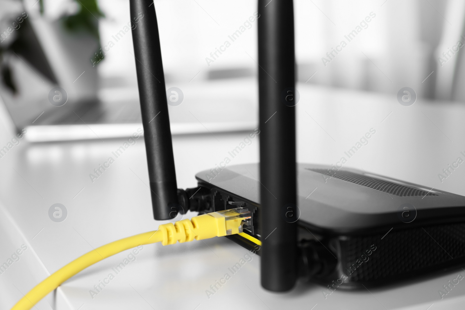 Photo of Connected cable to router on white table, closeup. Wireless internet communication