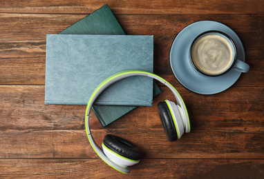 Books, coffee and headphones on wooden table, flat lay