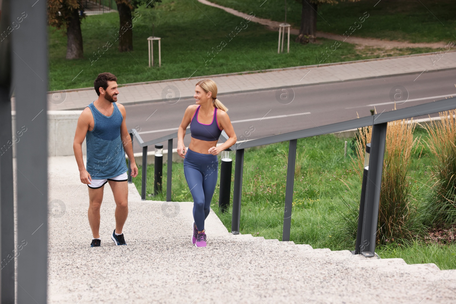 Photo of Healthy lifestyle. Happy couple running up stairs outdoors